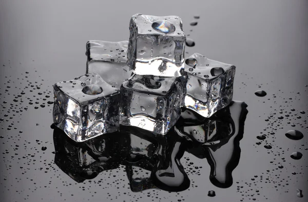 Cubes de glace fondus sur fond gris — Photo