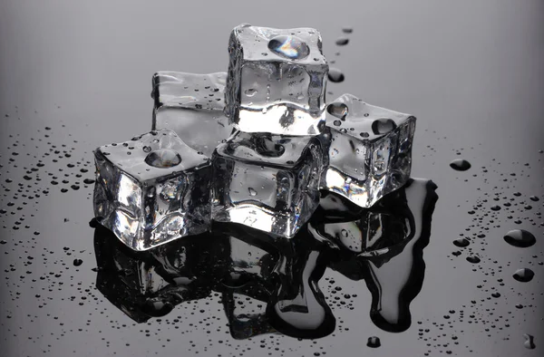 stock image Melting ice cubes on grey background