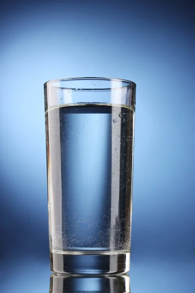 Szklanka wody na niebieskim tle — Zdjęcie stockowe