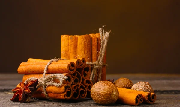 Корица палочки, мускатный орех и аниса на деревянном столе на коричневом фоне — стоковое фото