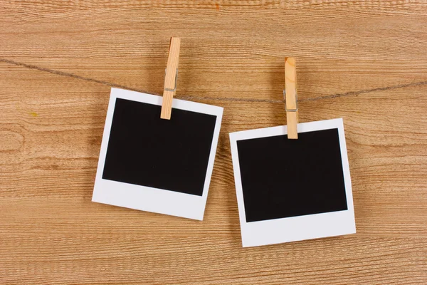 Carte fotografiche appese alla clothesline su sfondo di legno — Foto Stock