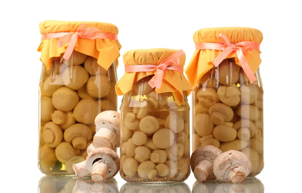 Deliciosos cogumelos marinados nos frascos de vidro e champinhons crus isolados — Fotografia de Stock