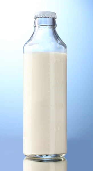 Flaska mjölk på blå bakgrund — Stockfoto