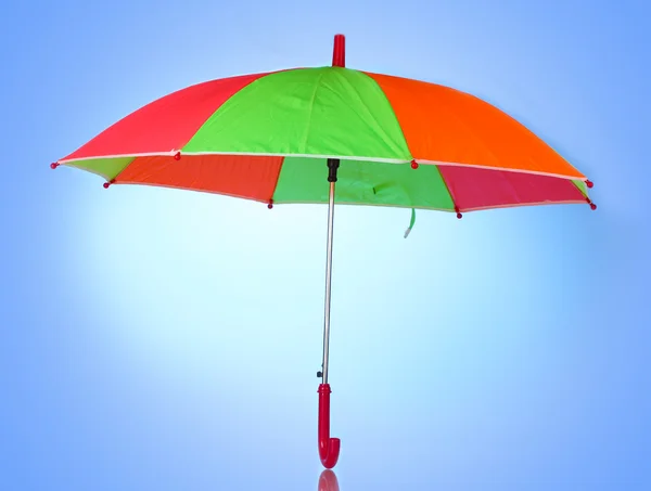 Multi-gekleurde paraplu op blauwe achtergrond — Stockfoto