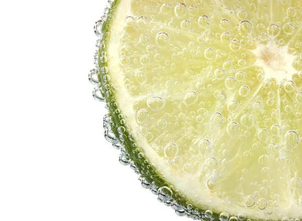 Slice of lime in the water with bubbles — Stock Photo, Image