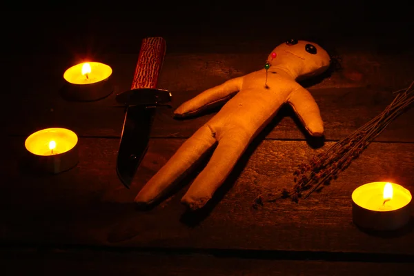 Voodoo panenka kluk na dřevěný stůl ve světle svíček — Stock fotografie