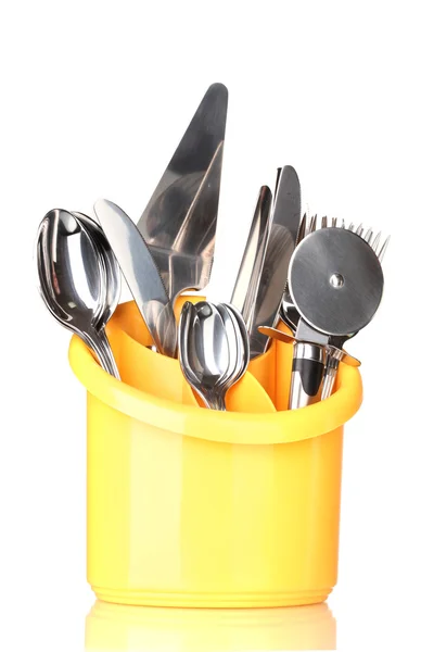 Кухонные столовые приборы, ножи, вилки и ложки в желтой стойке изолированы на белом — стоковое фото