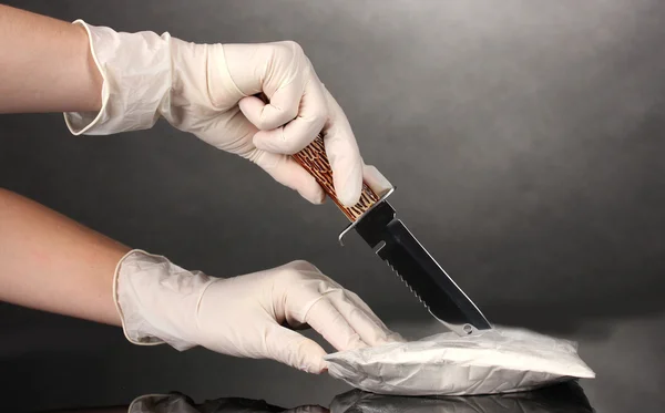 灰色の背景にナイフで開いてコカインのパケット — ストック写真