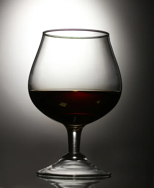 Bicchiere di cognac su fondo grigio — Foto Stock
