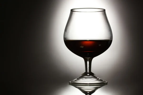 Glas cognac på grå bakgrund — Stockfoto