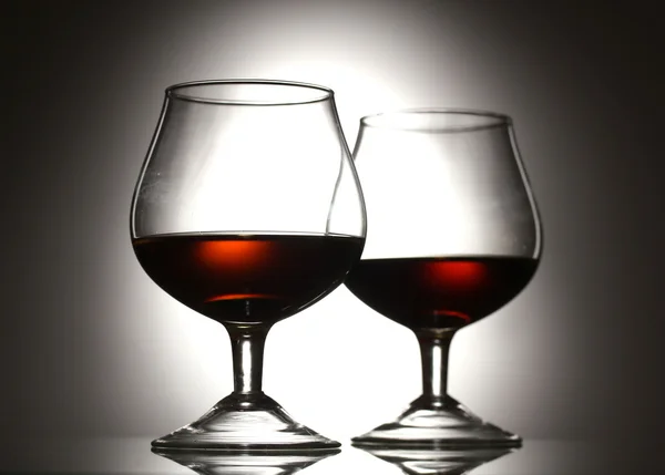 Twee glazen van cognac op grijze achtergrond — Stockfoto