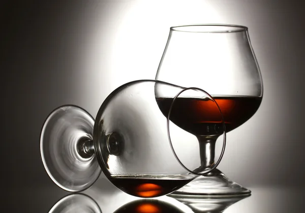 Dwie szklanki koniaku na szarym tle — Zdjęcie stockowe
