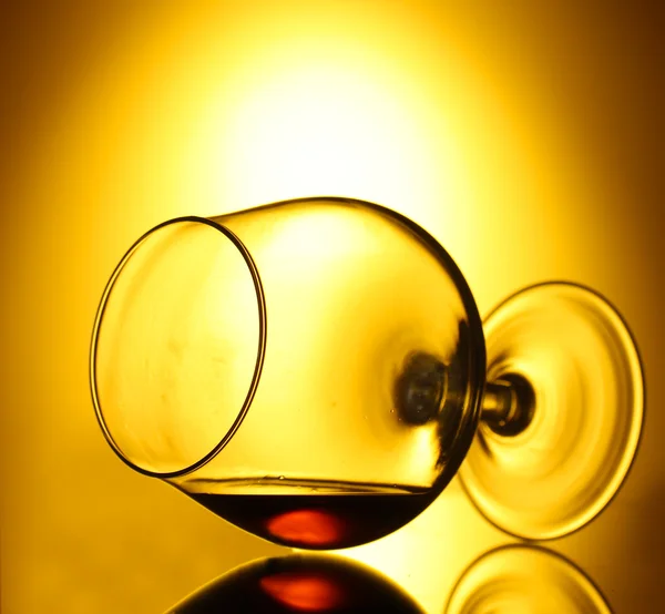 Bicchiere di cognac su fondo giallo — Foto Stock