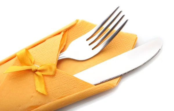 Fork and knife in a yellow cloth with a bow isolated on white — Stock Photo, Image