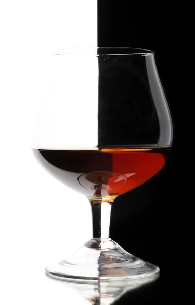 Glass of cognac on white-black background — Stock Photo, Image