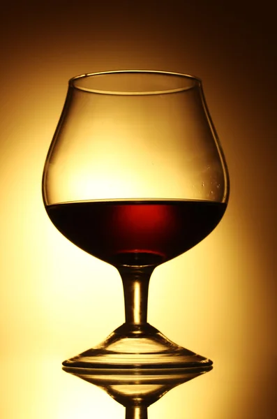 Bicchiere di cognac su fondo giallo — Foto Stock