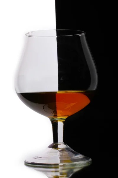 ホワイト ブラックの背景上のコニャックのガラス — ストック写真