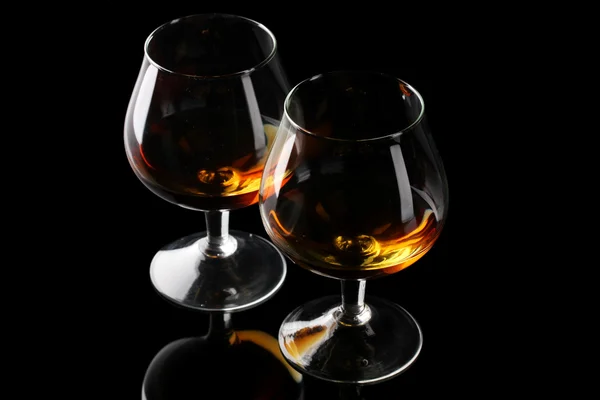 Två glas cognac på svart bakgrund — Stockfoto