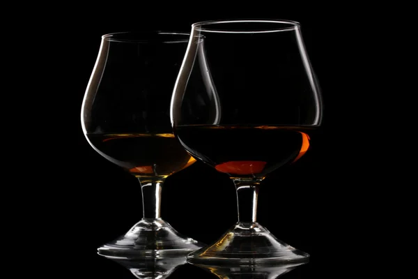 Două pahare de coniac pe fundal negru — Fotografie, imagine de stoc