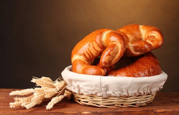 Pişmiş ekmek sepeti kahverengi zemin üzerine ahşap tablo — Stok fotoğraf