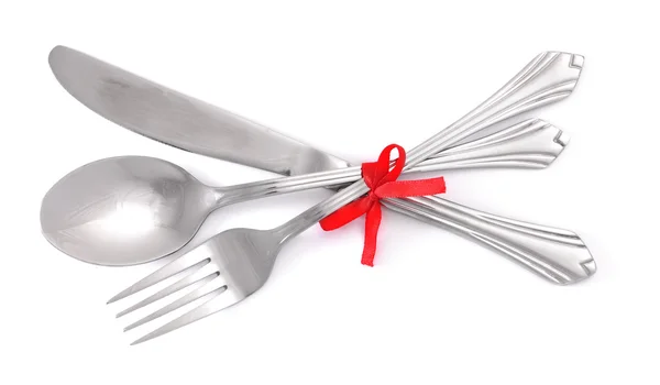 银叉子和勺子，刀与孤立白底红丝带绑 — 图库照片