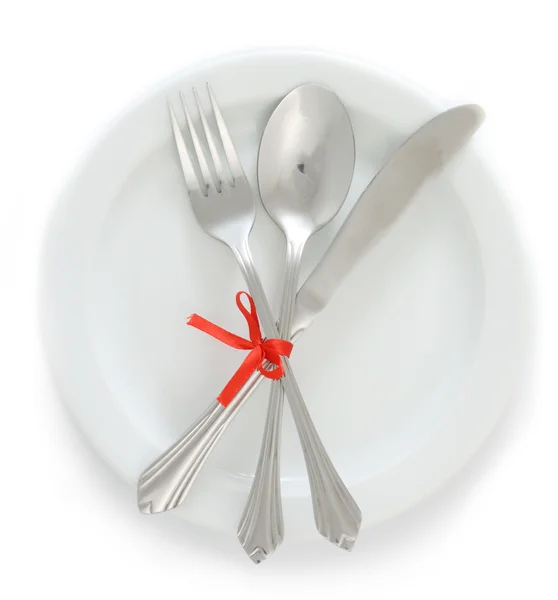 Placa vazia branca com garfo e colher de prata, faca amarrada com uma fita vermelha — Fotografia de Stock