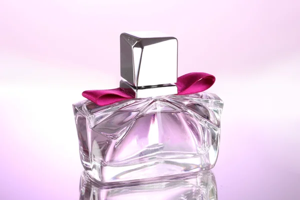 Женские духи в красивой бутылке на розовом фоне — стоковое фото