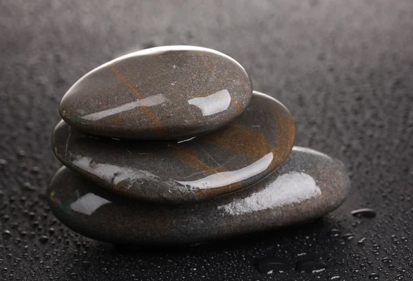 Lázeňské kameny s kapkami vody na černém pozadí — Stock fotografie