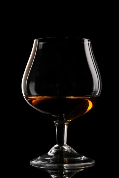 Szklanka koniaku na czarnym tle — Zdjęcie stockowe