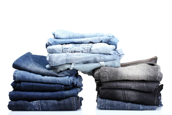Många blå jeans isolerade på vitt — Stockfoto