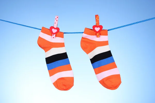 Heldere gestreepte sokken op lijn op blauwe achtergrond — Stockfoto