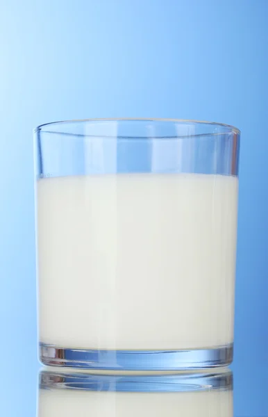 美味牛奶在蓝色背景上的玻璃 — 图库照片