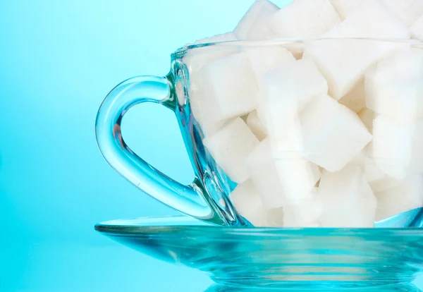Raffinierter Zucker in einer Tasse auf blauem Hintergrund — Stockfoto