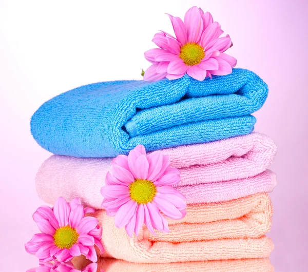Toalhas e flores bonitas no fundo rosa — Fotografia de Stock