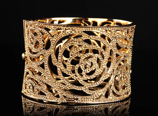 Hermosa pulsera de oro sobre fondo negro —  Fotos de Stock