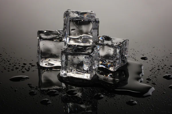 灰色の背景上の氷の融解 — ストック写真