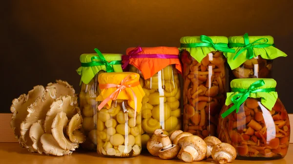 Delicious marinated mushrooms in the glass jars, raw champignons and oyster — Stock Photo, Image