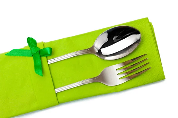 Fork and spoon in a green cloth with a bow isolated on white — Stock Photo, Image