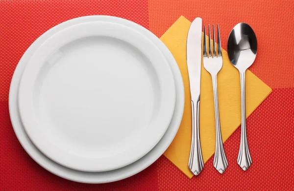 화이트 빈 접시와 포크, 스푼 및 나이프 빨간색 식탁보에 — 스톡 사진