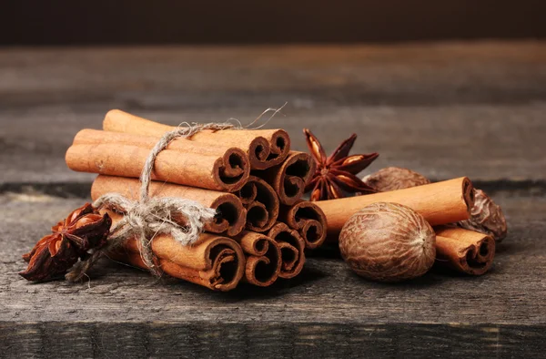 Коричные палочки, мускатный орех и анис на деревянном столе — стоковое фото