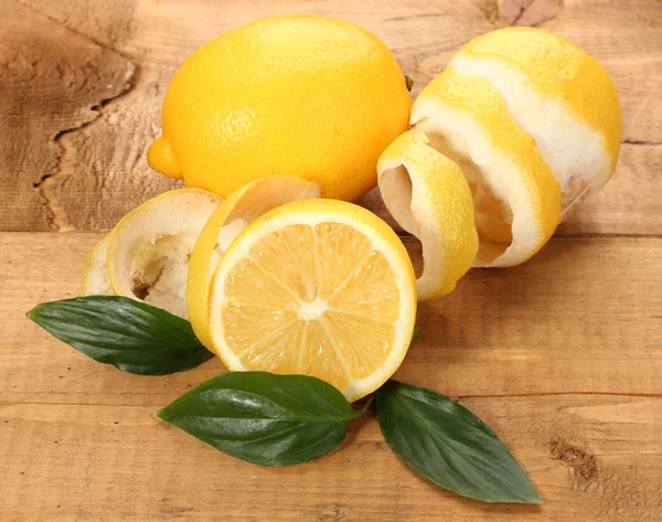 Limones maduros con hojas sobre mesa de madera — Foto de Stock
