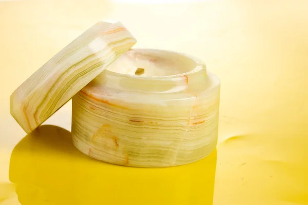 黄色の背景にクリームの jar ファイルを開く — ストック写真