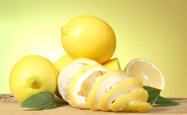 Zralých citronů s listy na dřevěný stůl na zeleném pozadí — Stock fotografie