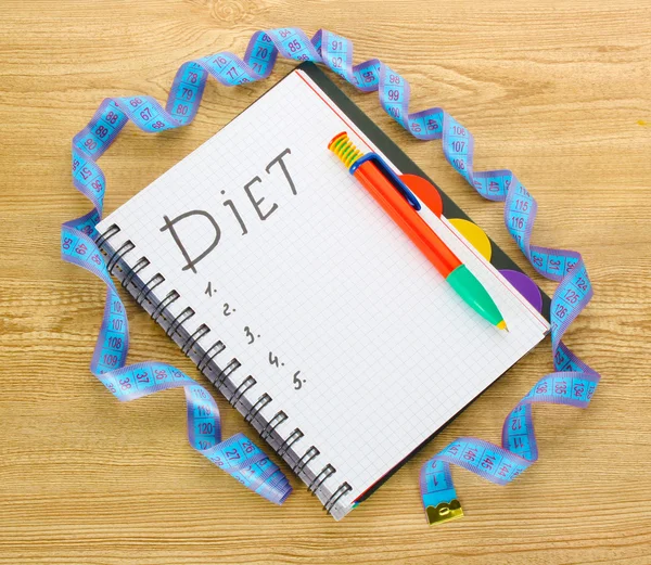 Planificación de la dieta. Cinta métrica portátil y bolígrafo en mesa de madera —  Fotos de Stock