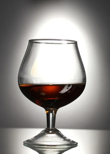 Glas cognac op grijze achtergrond — Stockfoto