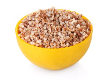 Boiled buckwheat in a yellow bowl isolated on white clipart