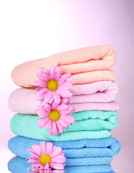 Πετσέτες και όμορφα λουλούδια σε ροζ φόντο — Φωτογραφία Αρχείου