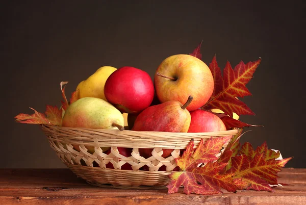 バスケットと茶色の背景に葉の美しい秋の収穫 — ストック写真