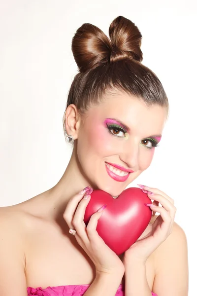 Chica joven como una muñeca en vestidos de color rosa con el corazón aislado en blanco —  Fotos de Stock