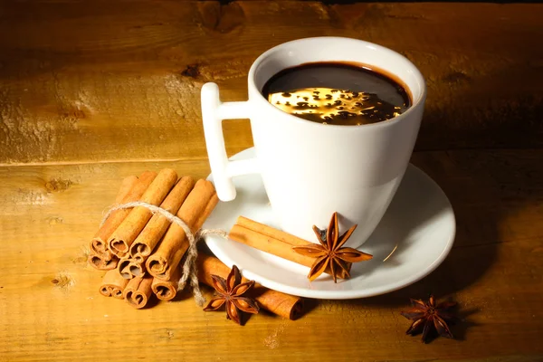 Kopje warme chocolademelk, kaneelstokjes, noten en chocolade op houten tafel — Stockfoto